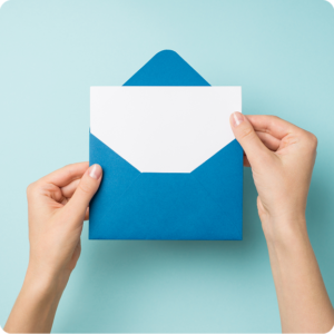 Hands holding blue envelope and white card.