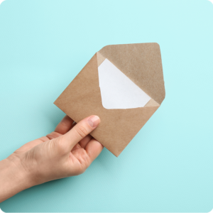 Hand holding open brown envelope on blue.