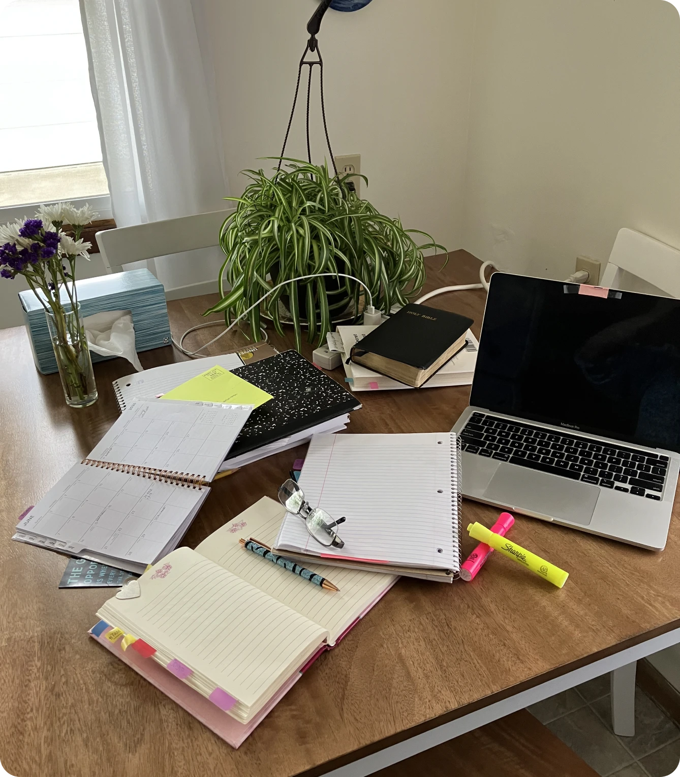 Home office desk with laptop and notebooks.