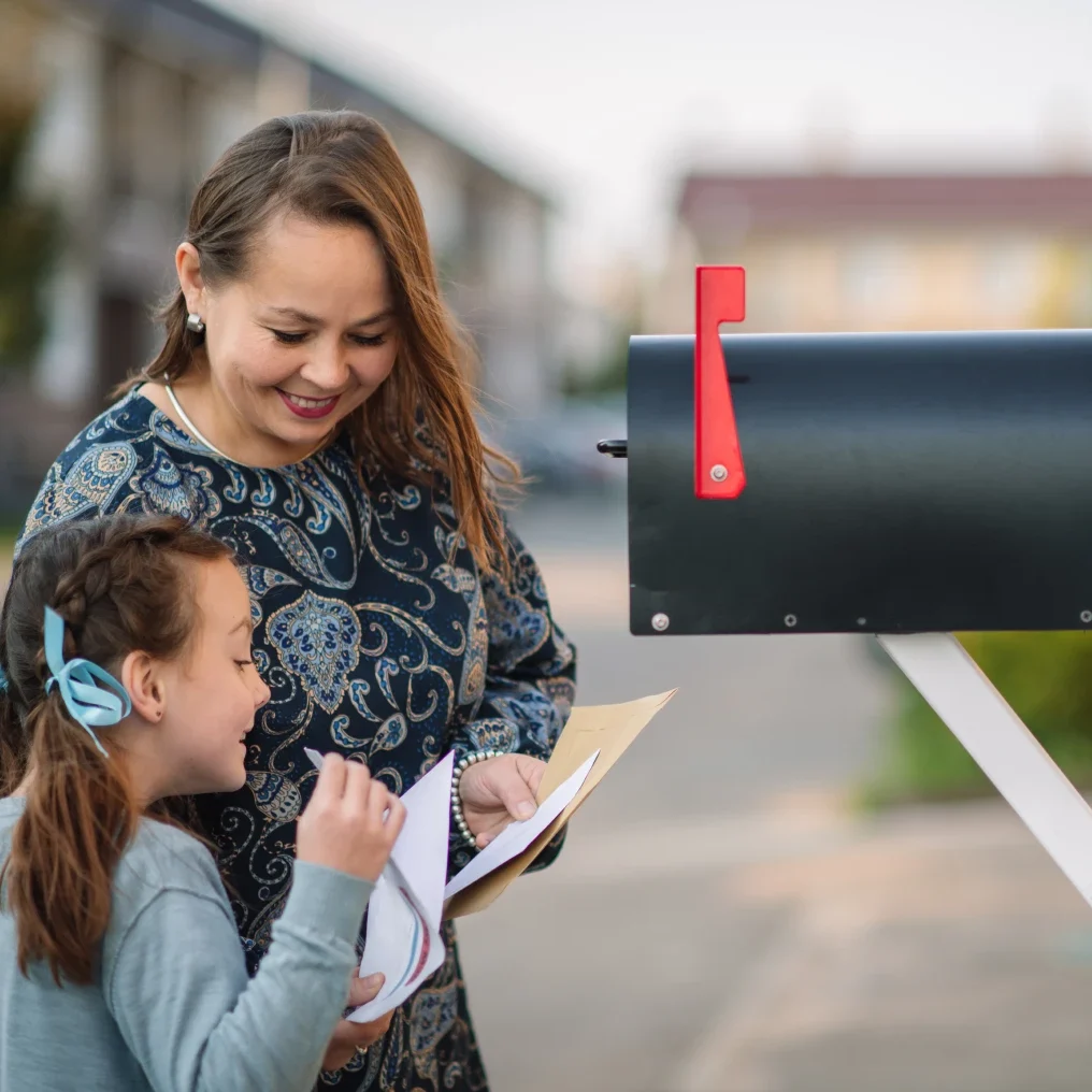 Mother and daughter checking mailbox together.